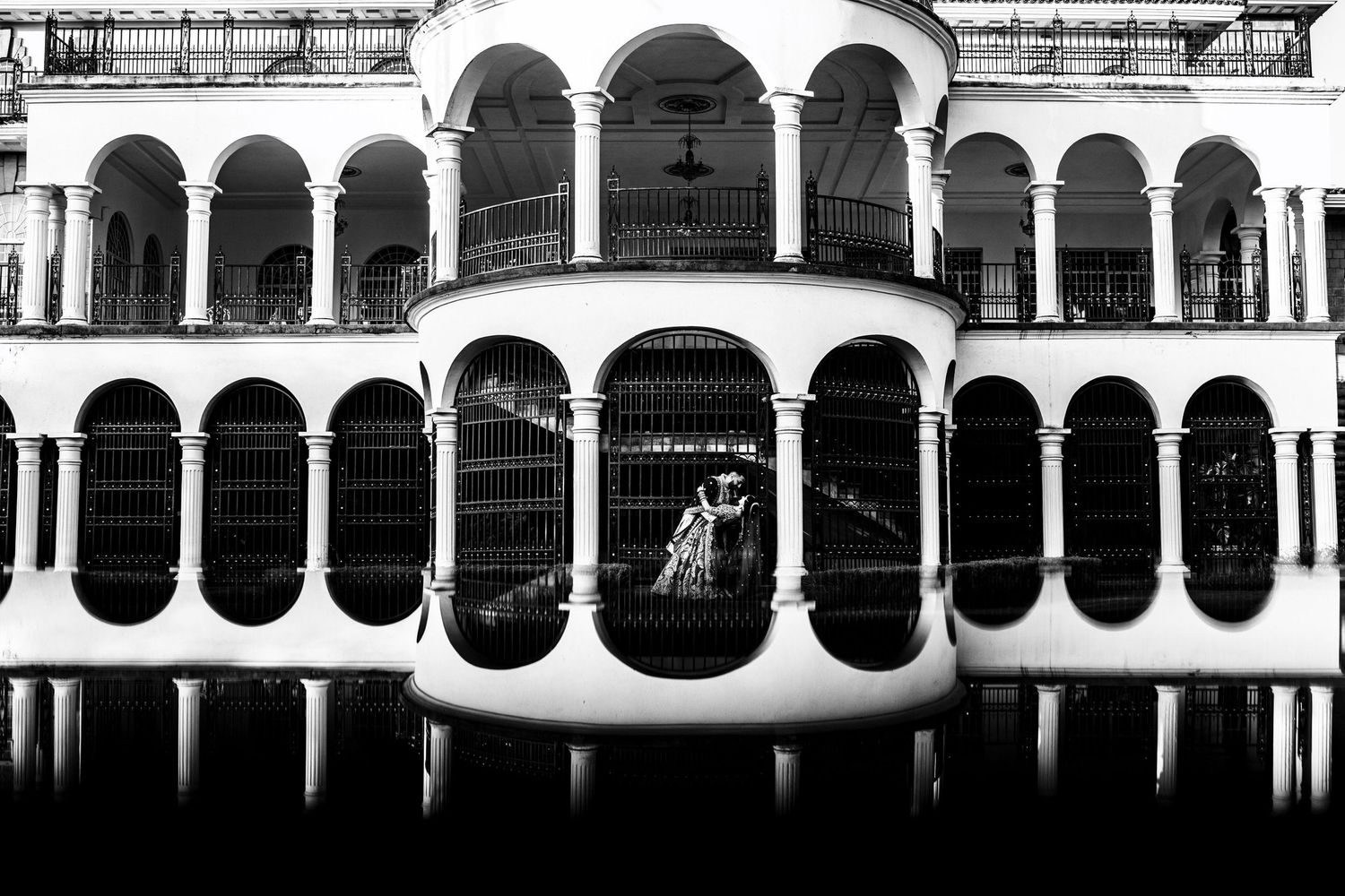 Black and white architectural photo of classical arches creating repetitive patterns.