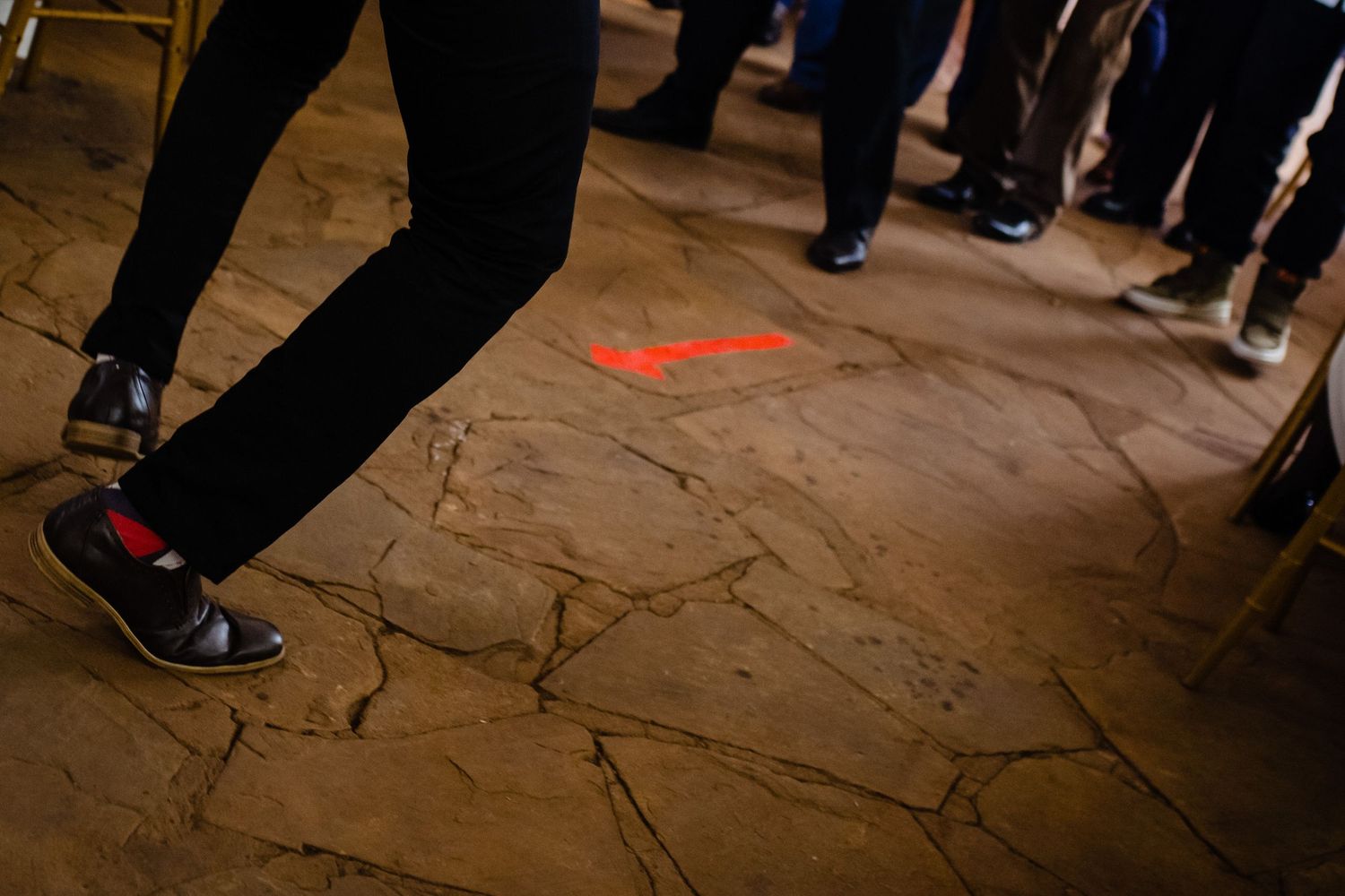 Close-up view of wedding guests' feet dancing on stone floor.