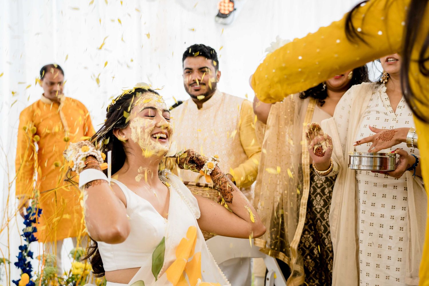 Joyful celebration with confetti and traditional outfits during a cultural wedding ceremony.