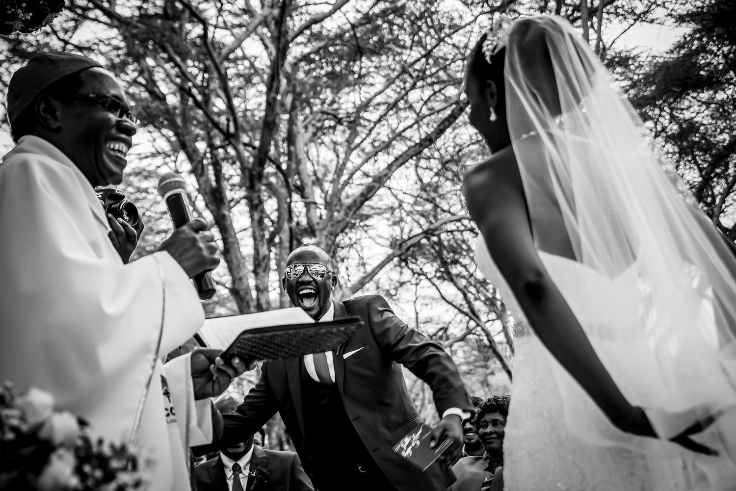 Candid wedding moments captured in a series of black and white photographs outdoors.