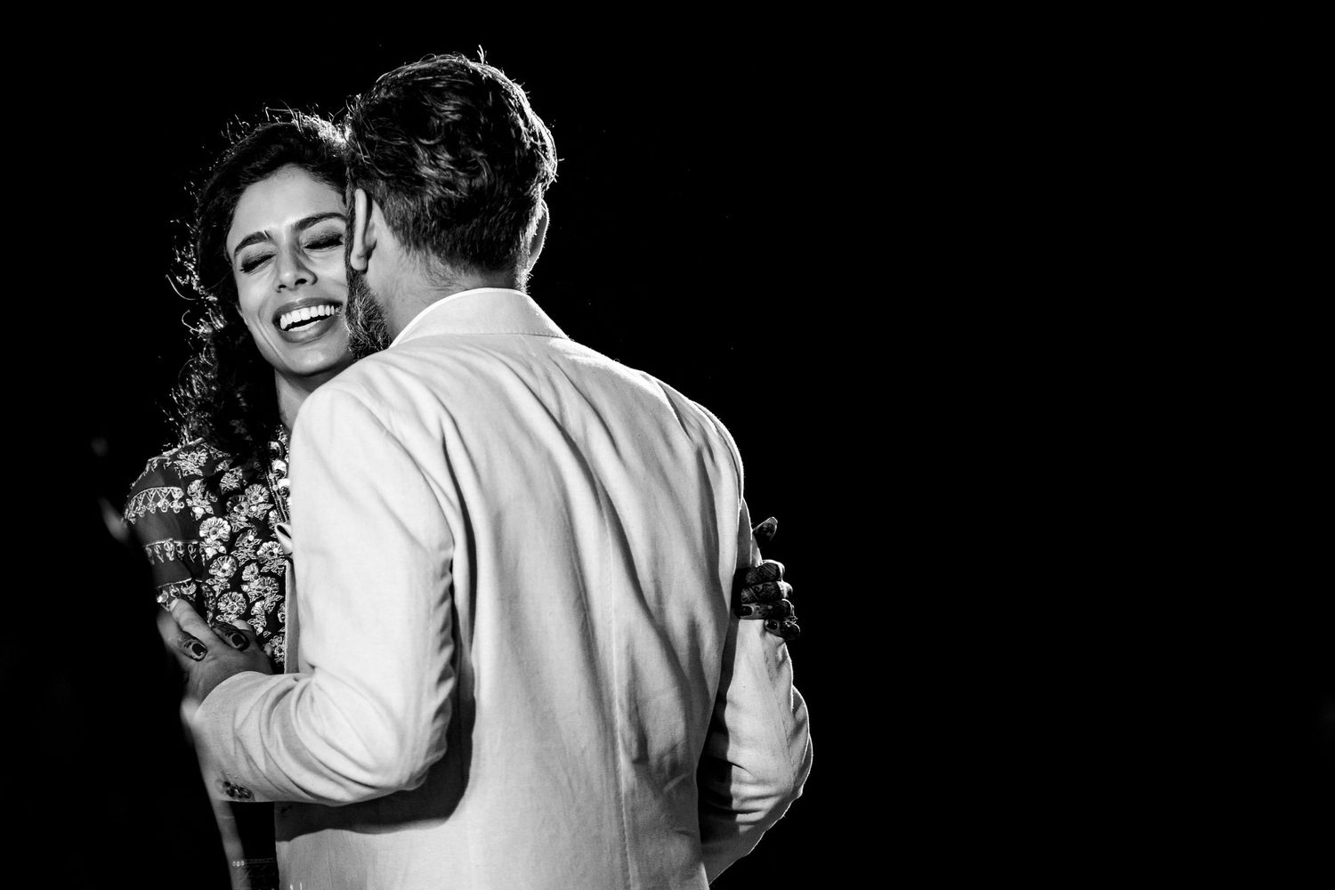 Black and white candid shots of joyful dancing at wedding reception.