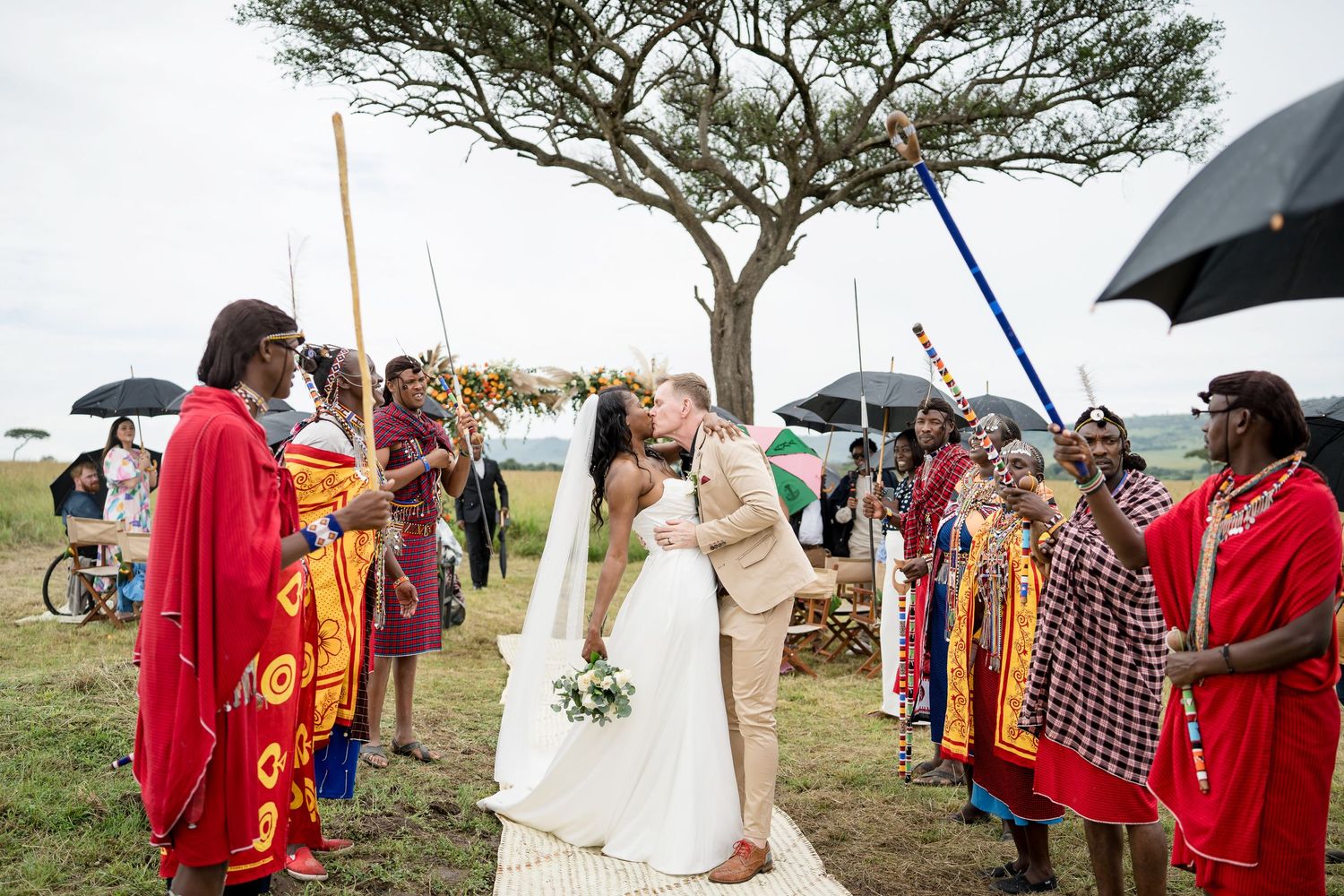 Wedding ceremony in Kenya with traditional Maasai warriors forming an honor guard under an acacia tree.