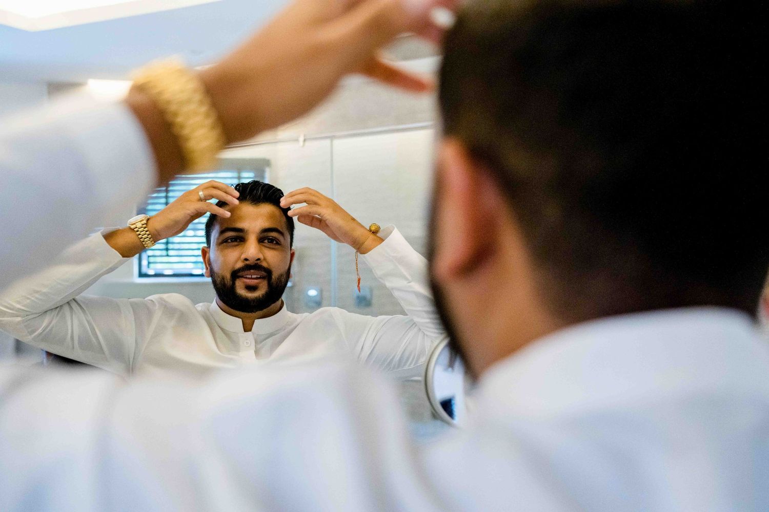 Mirror reflection showing wedding preparation and traditional grooming moments.