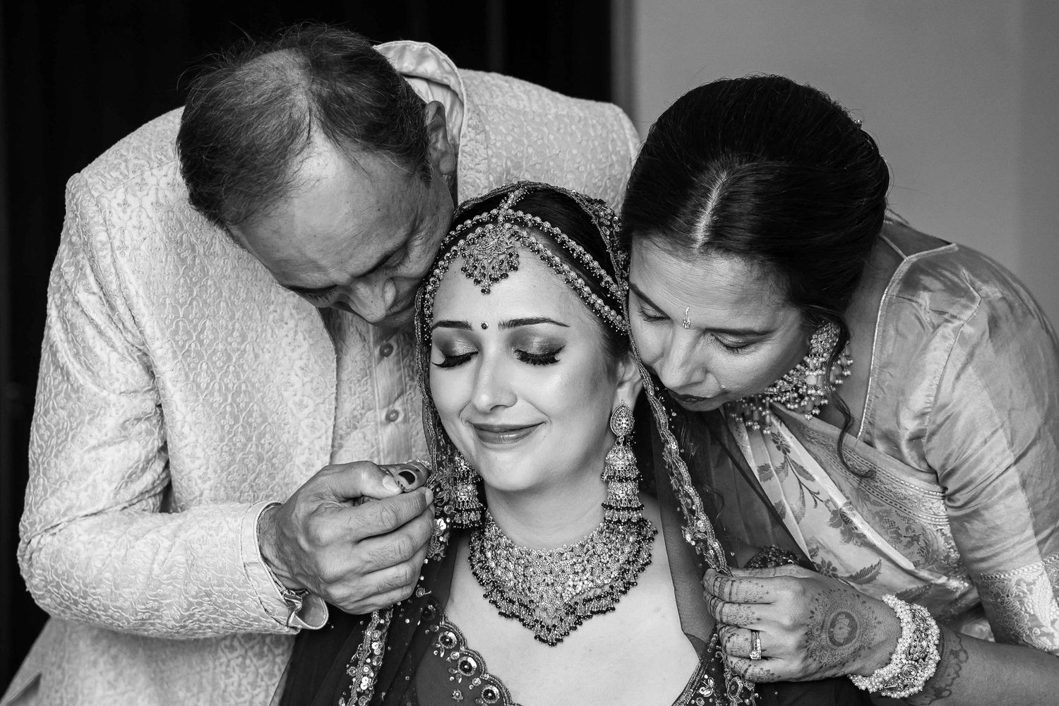 A black and white collage of intimate wedding moments showing emotional reactions and tender embraces.
