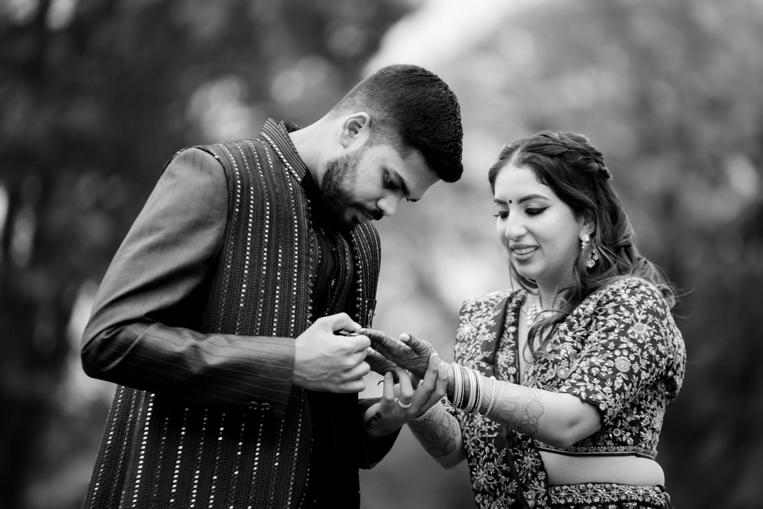 A couple in traditional Indian attire share a tender moment during what appears to be an engagement ceremony.