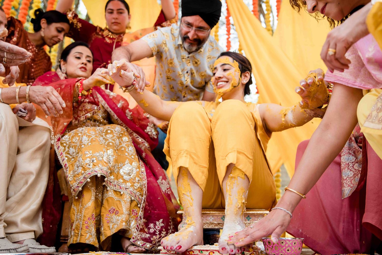 Wedding celebration with guests throwing flower petals during joyous traditional ceremony.