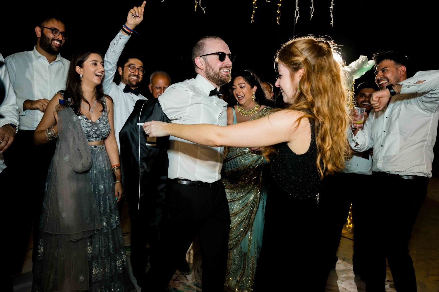People dancing and celebrating together at a lively wedding reception party on the dance floor.