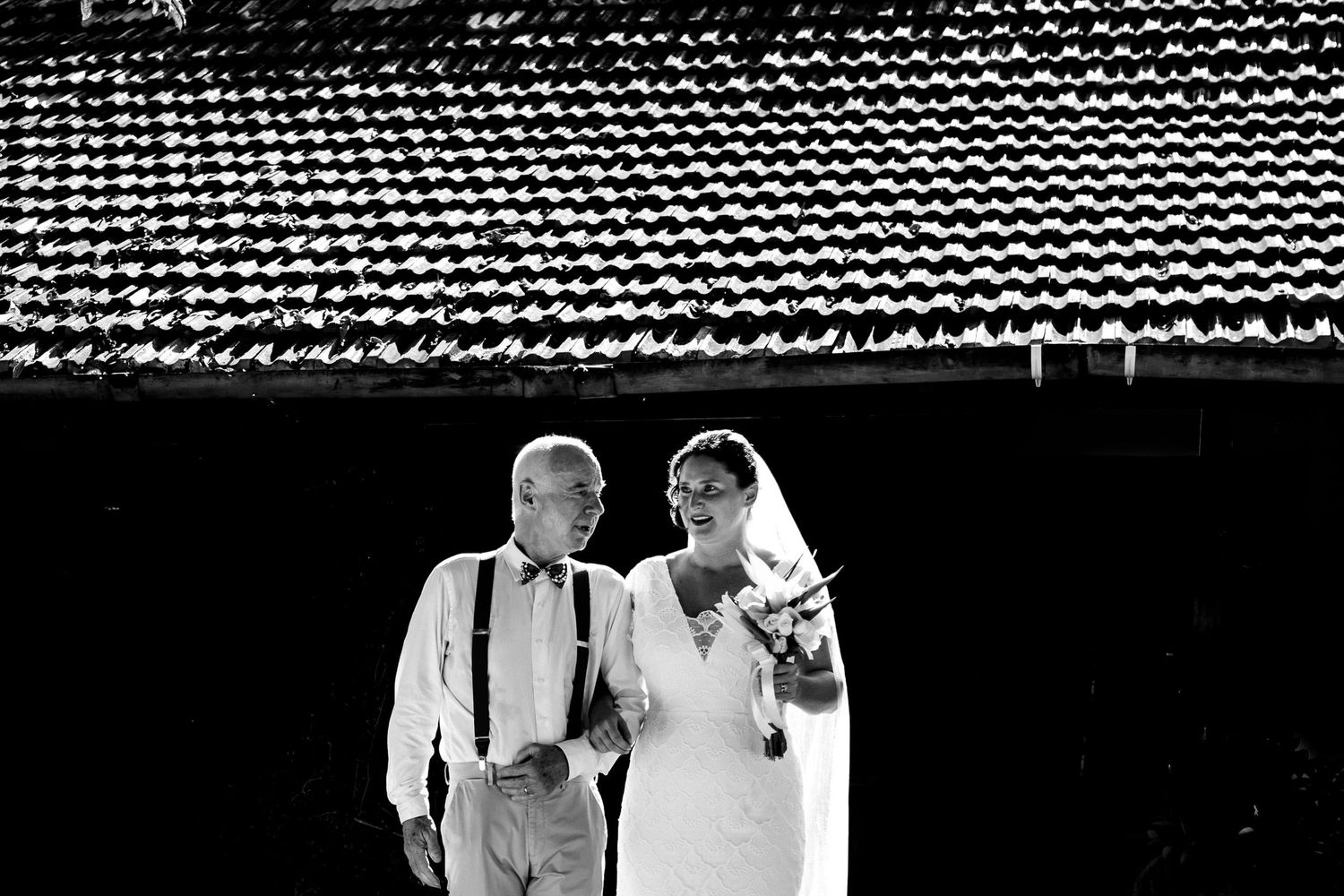 Black and white panoramic view of guests seated at an outdoor wedding ceremony.