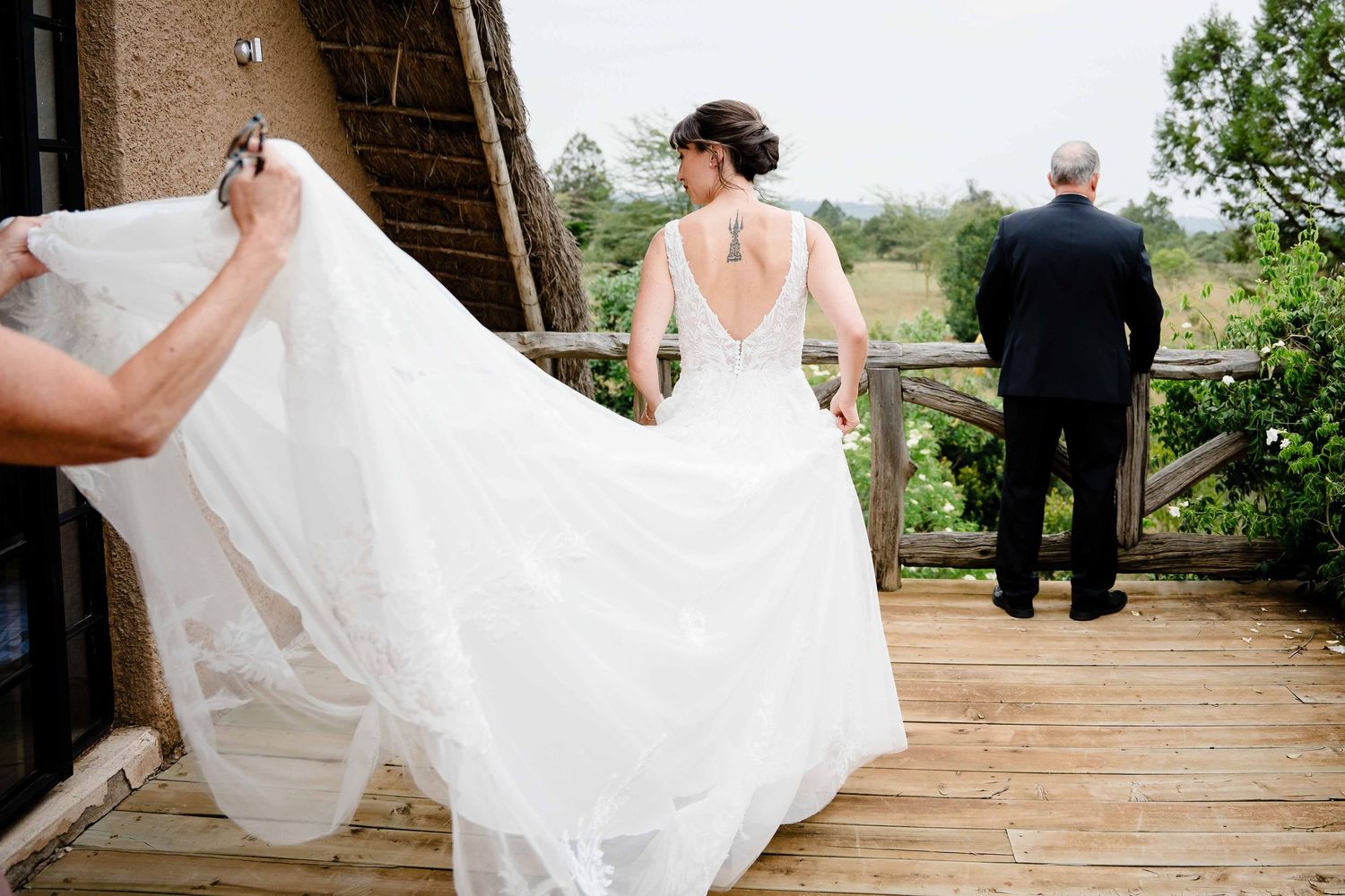 A romantic outdoor wedding ceremony on a stone patio surrounded by lush greenery and gardens.