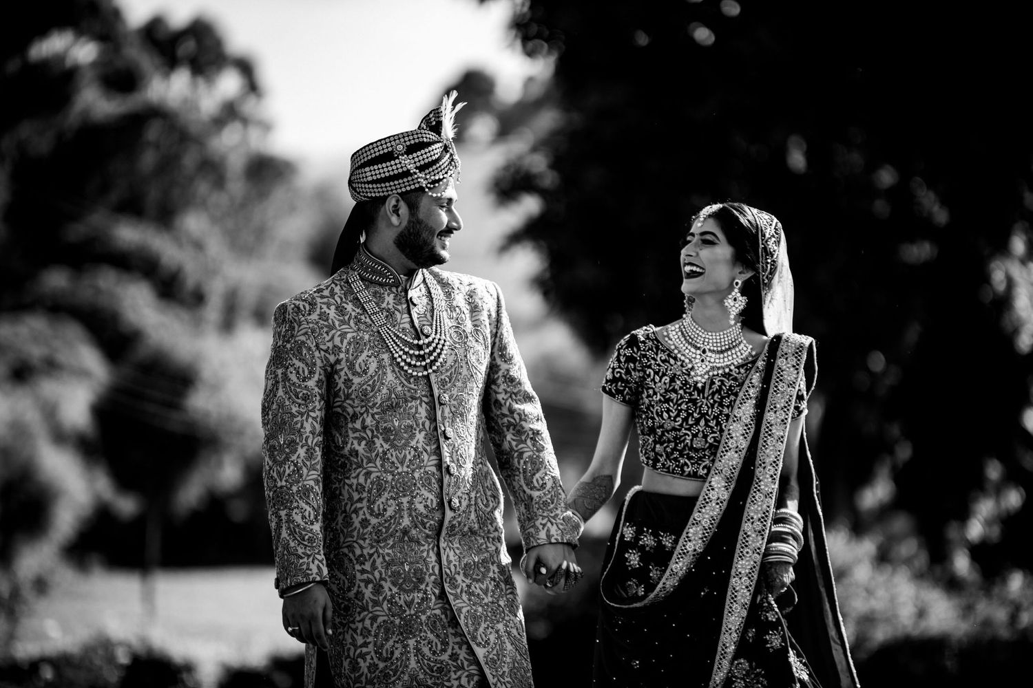 Black and white wedding portraits showing elegant traditional Indian attire and jewelry.