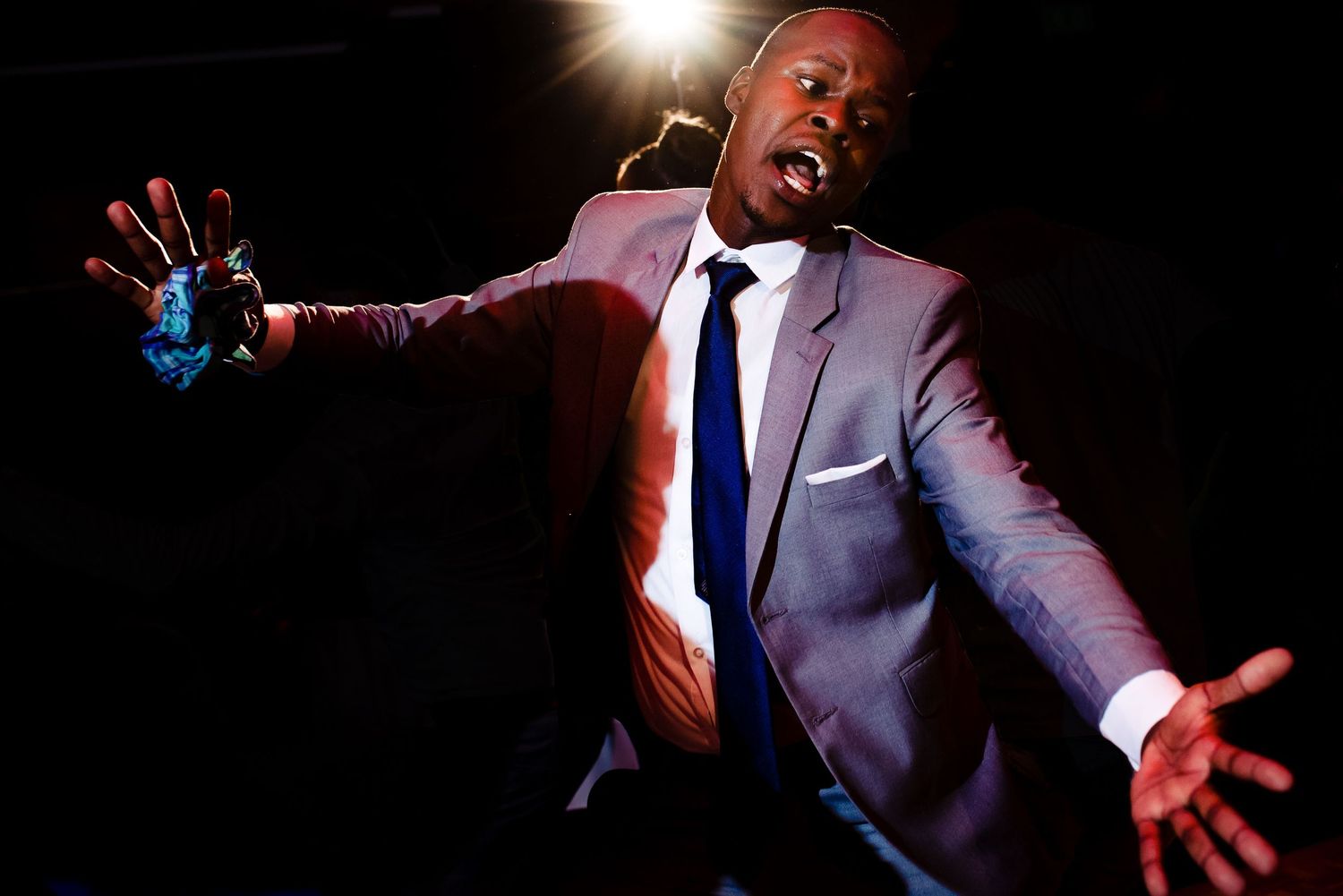 Dynamic dance moves captured in dramatic lighting at wedding reception.