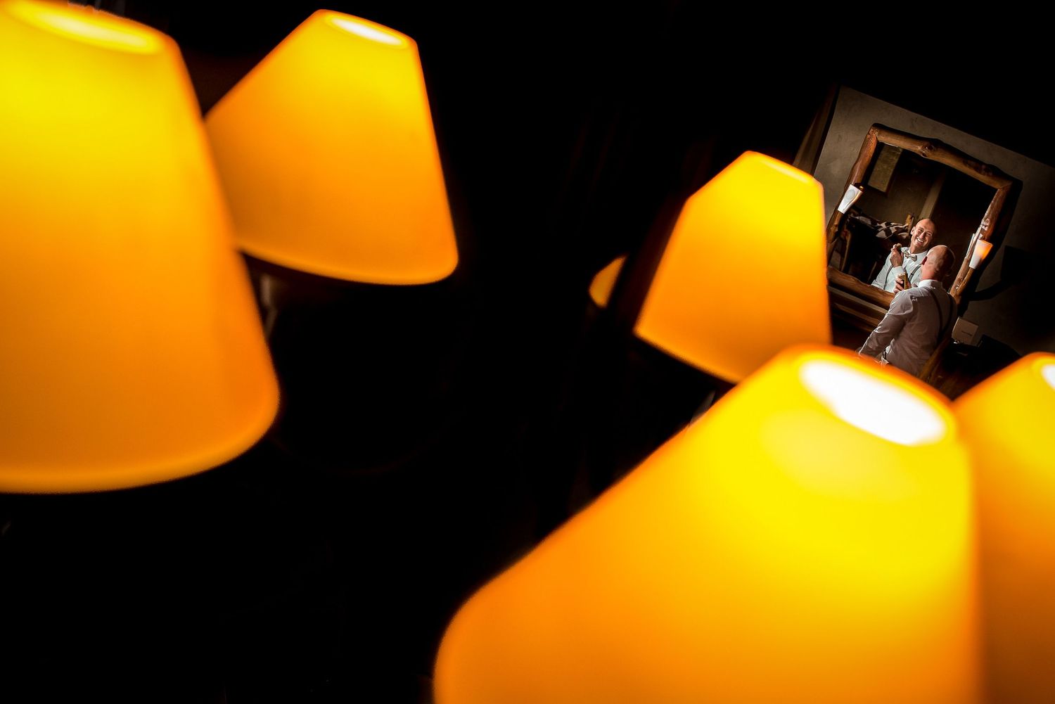 Multiple illuminated yellow lampshades create a warm atmospheric glow in darkness.