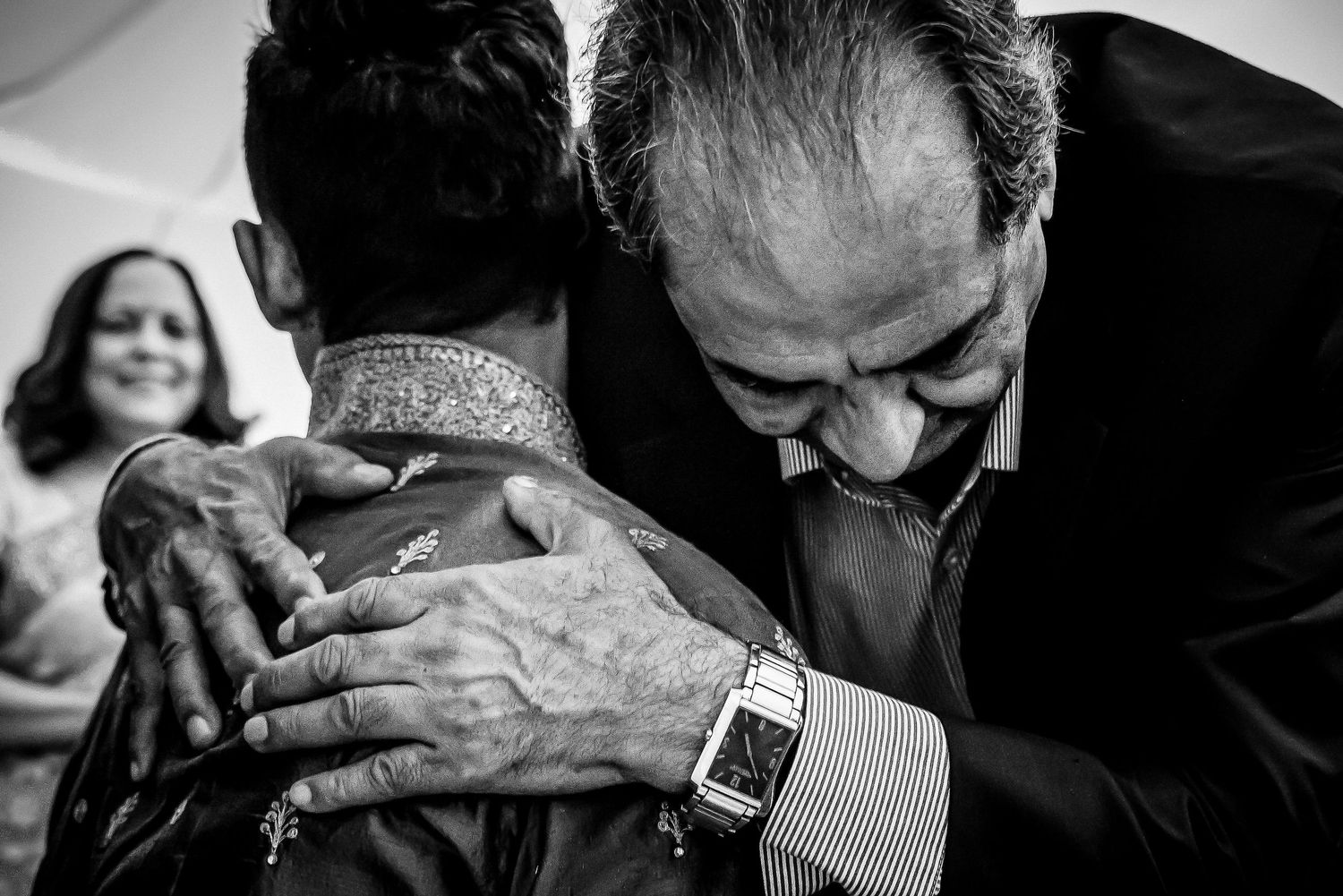 Black and white photo capturing emotional moments between wedding guests.