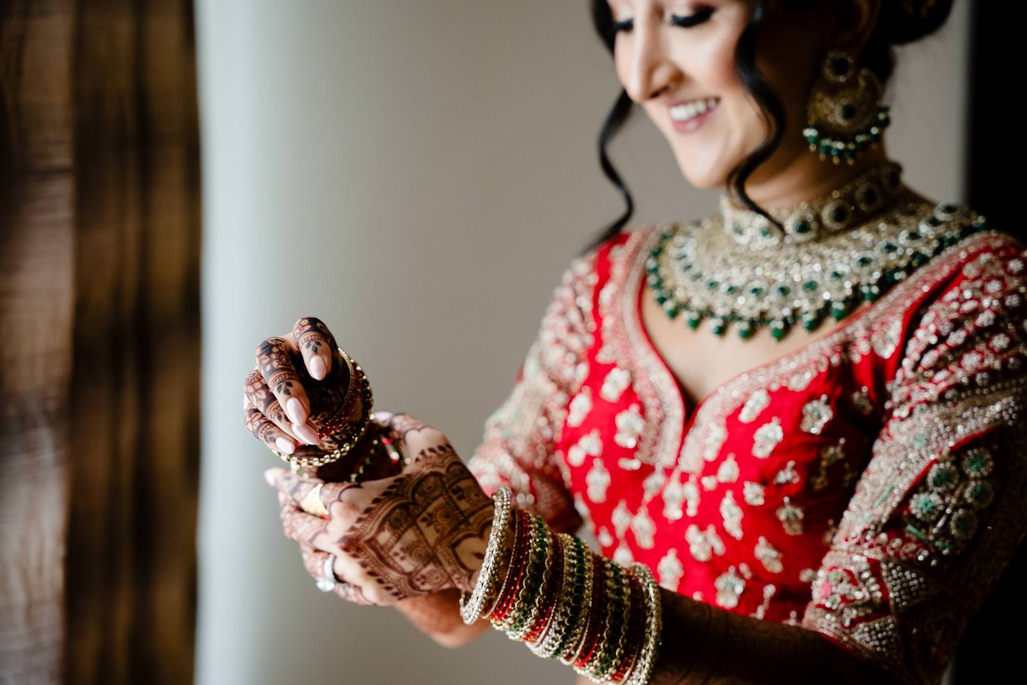 Traditional Indian wedding attire with detailed red and gold embroidery and ornate jewelry on display.
