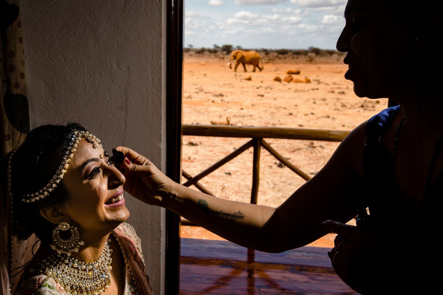 Silhouetted figures in a doorway with African savanna landscape visible through the opening.