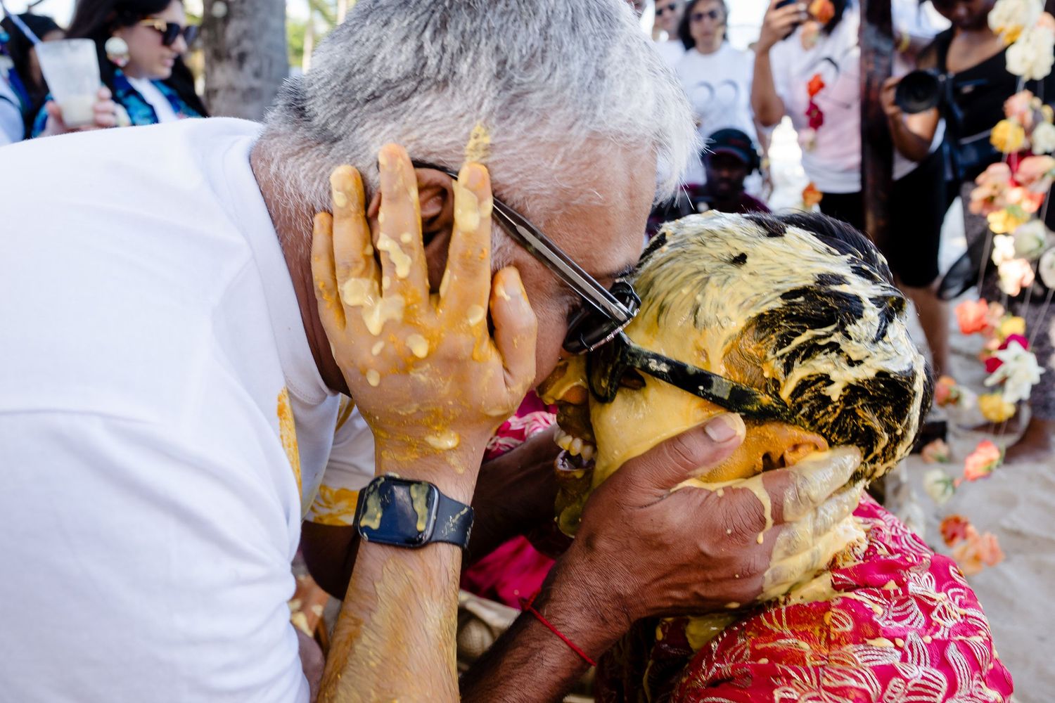 A group of people participate in a traditional Hindu Holi festival celebration with colorful powder and joyful expressions.