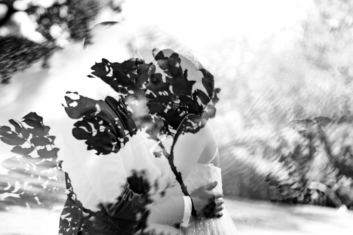 An artistic black and white wedding photo with soft focus floral elements.