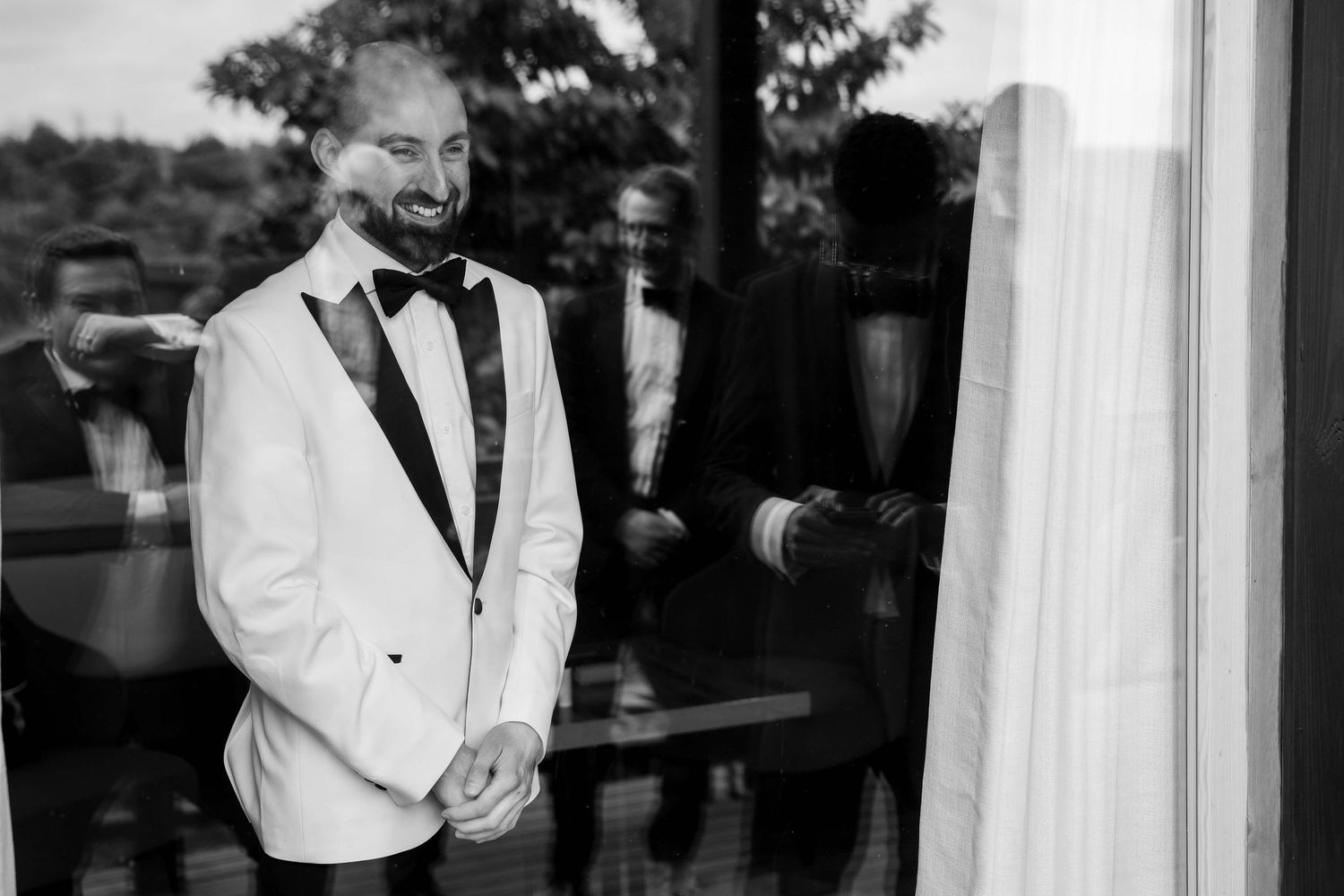 A series of black and white wedding photos showing moments between couples in formal attire at a reception.
