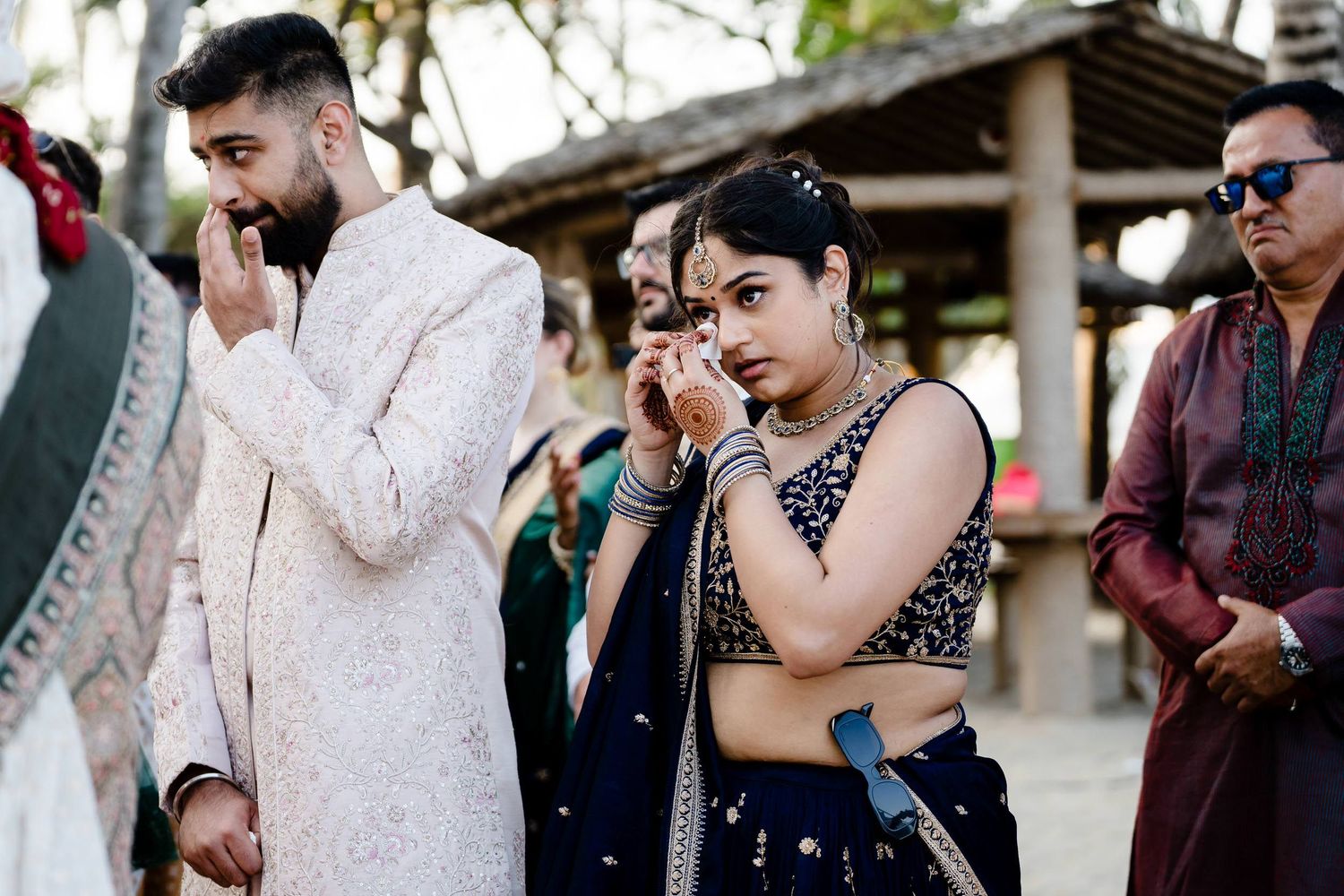Wedding guests share joyful reactions and emotional moments during an outdoor celebration.