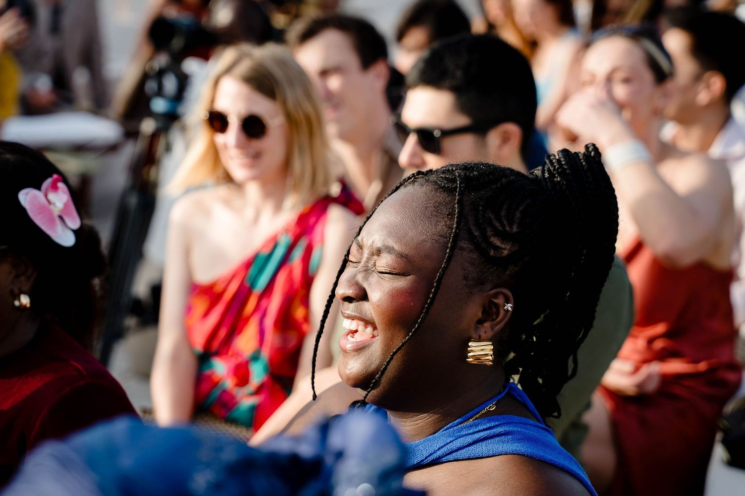 A diverse crowd of people sitting in an audience enjoying a performance or event.