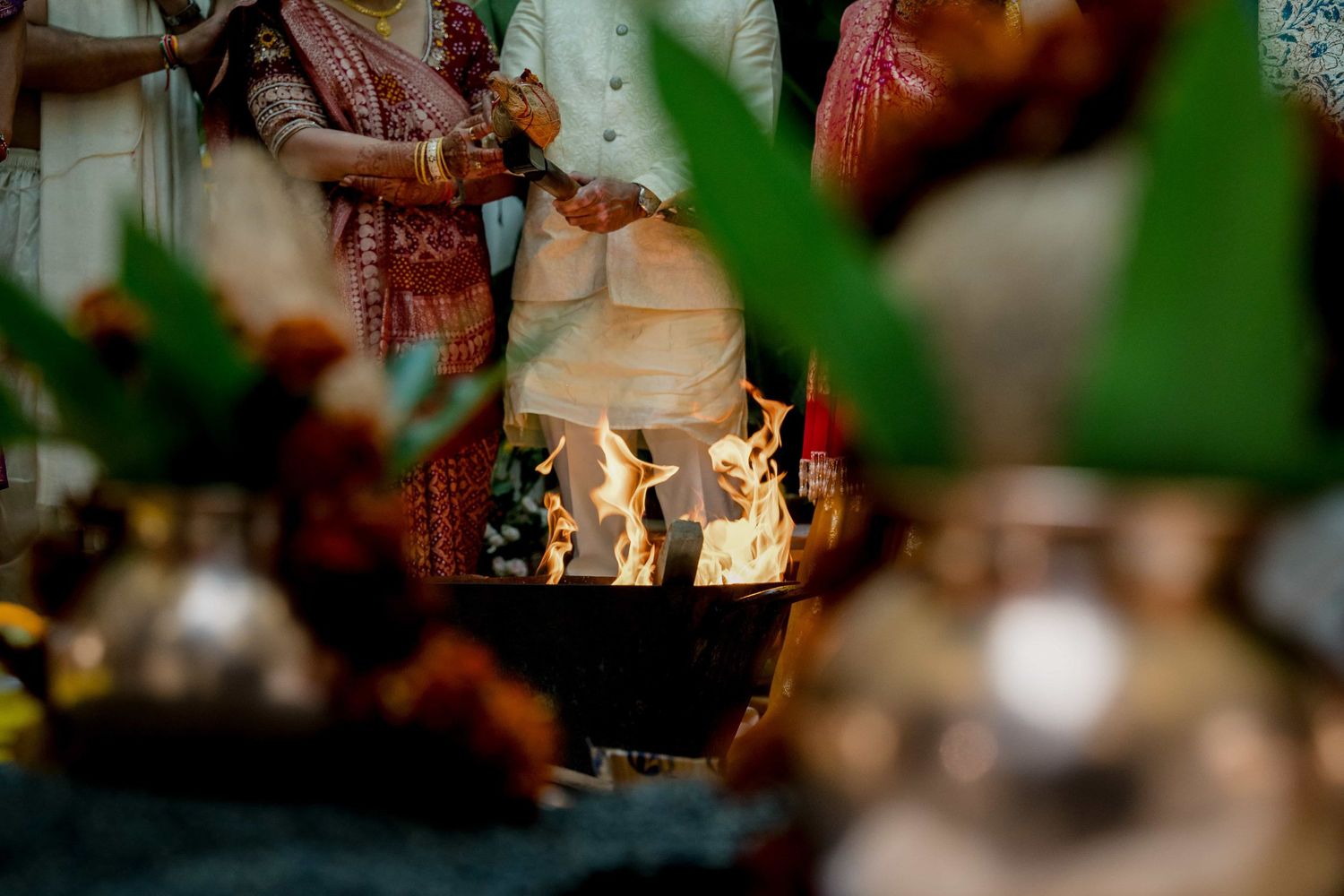 Sacred fire ceremony with flames visible through decorative elements at Indian wedding.