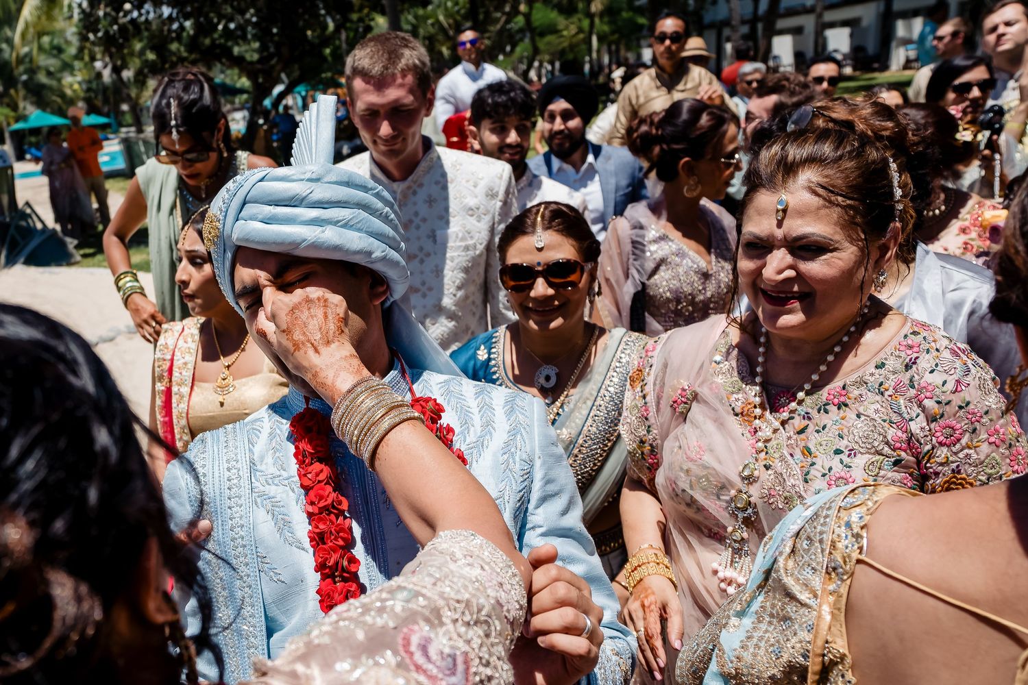 Energetic outdoor celebration with guests dancing and celebrating under sunny skies.