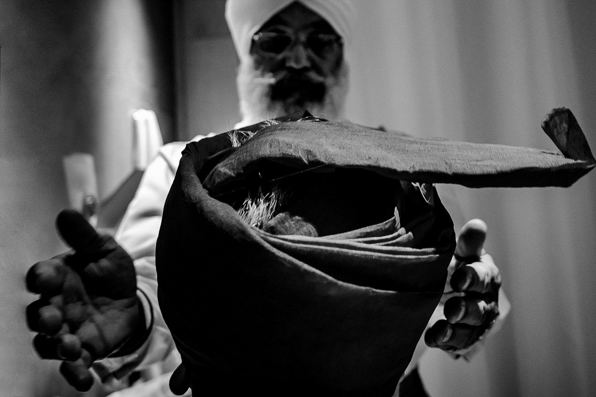 Elegant black and white detail shot of hands during wedding ceremony preparations.