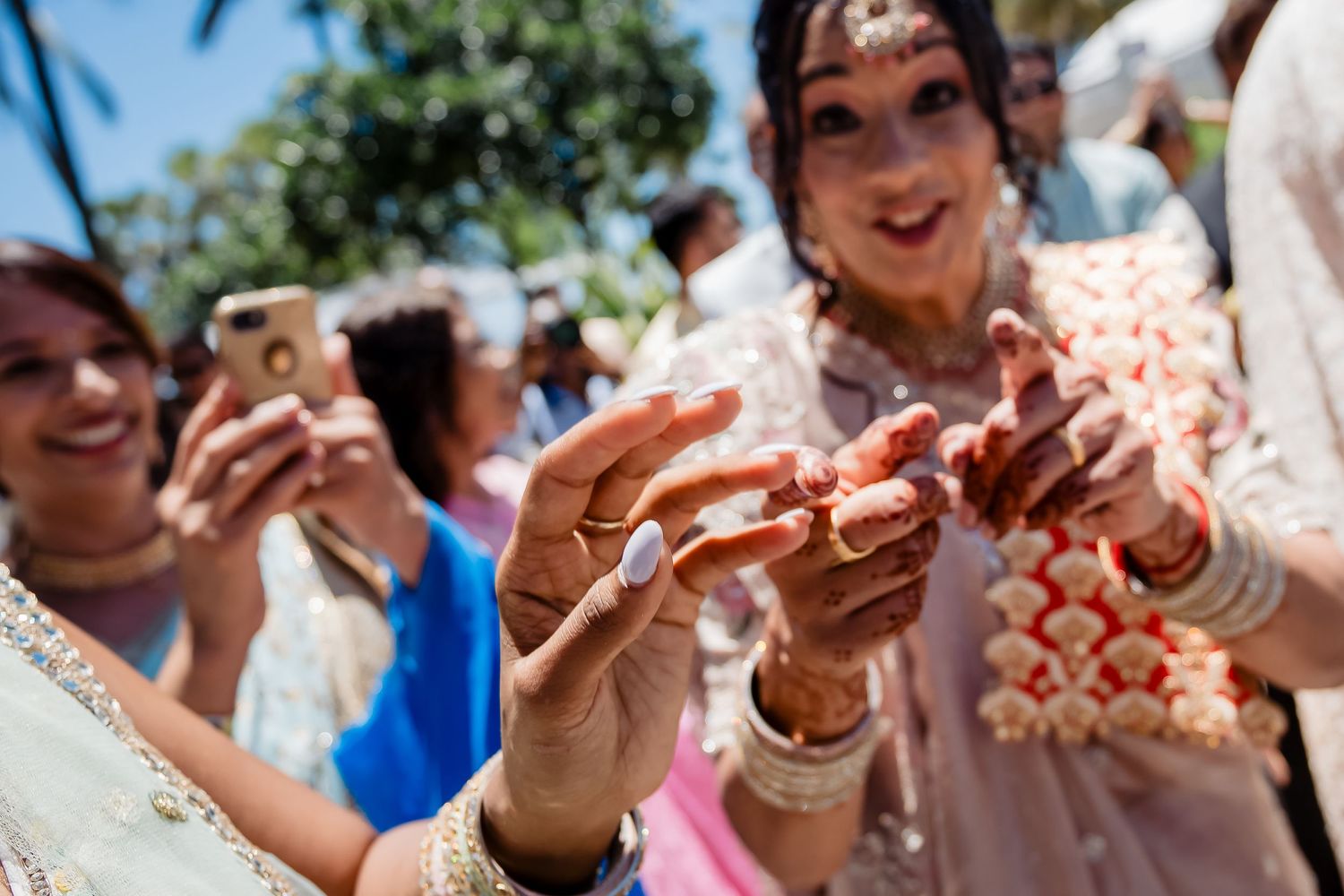 Close-up of hands with decorative henna during a cultural celebration outdoors.