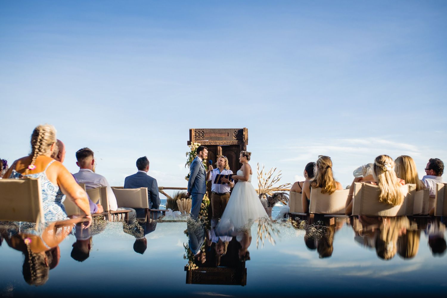 Upside down reflection shots of a wedding party against a bright blue sky.