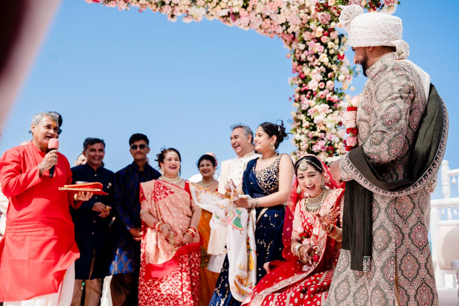 Group of people having fun throwing red confetti during an outdoor celebration event.