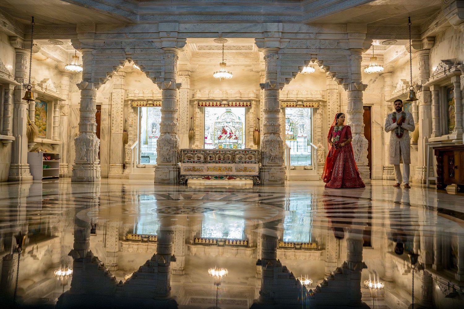 Ornate marble hall with reflective floors and traditional Indian architectural details.