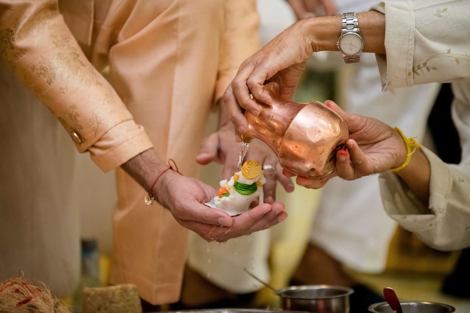 Hands performing a traditional Indian ceremony with ritualistic items and offerings.