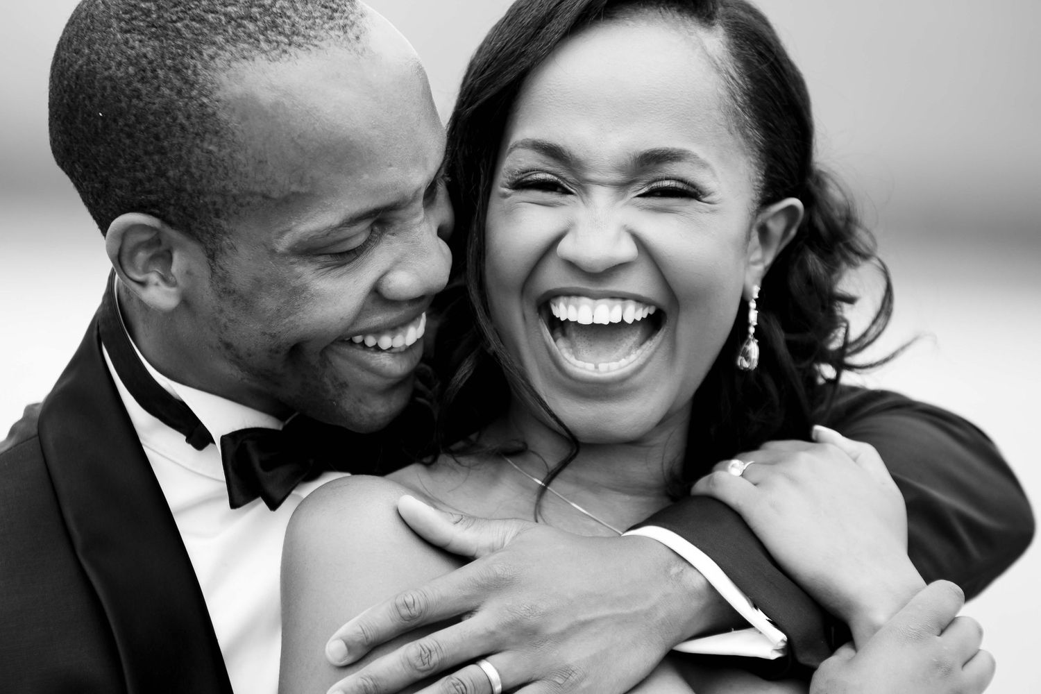 A joyful black and white candid moment between a couple.