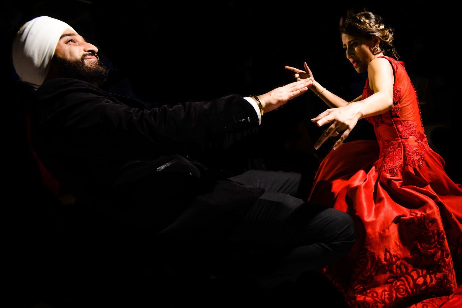 Dancers perform an elegant tango with dramatic movements in red and black costumes on stage.