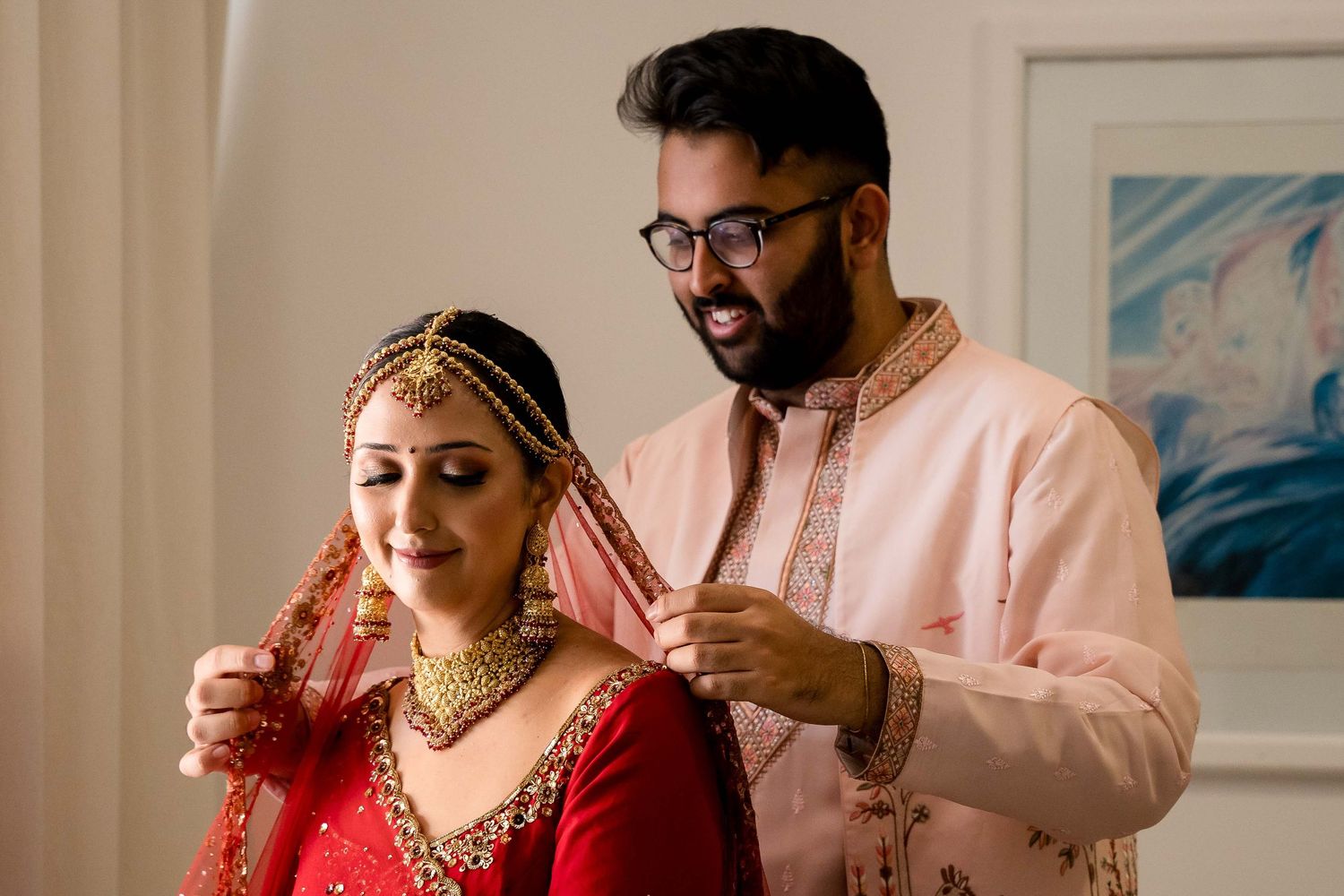 A couple in traditional Indian wedding attire shares an intimate moment during their ceremony celebration.