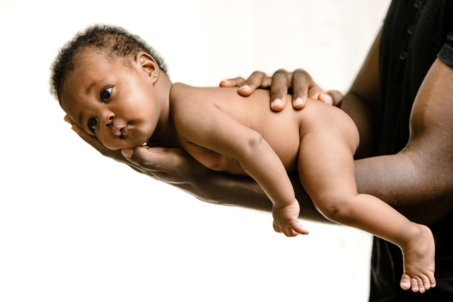 Black and white artistic photos of gentle interactions with baby against white background.
