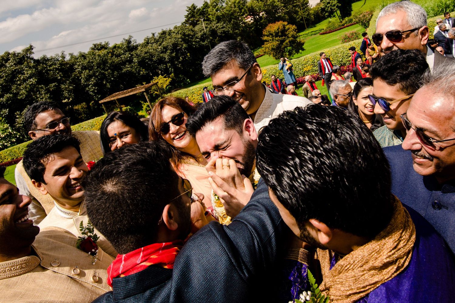 Large group of celebrants gathered outdoors under a cloudy sky during a festive event.