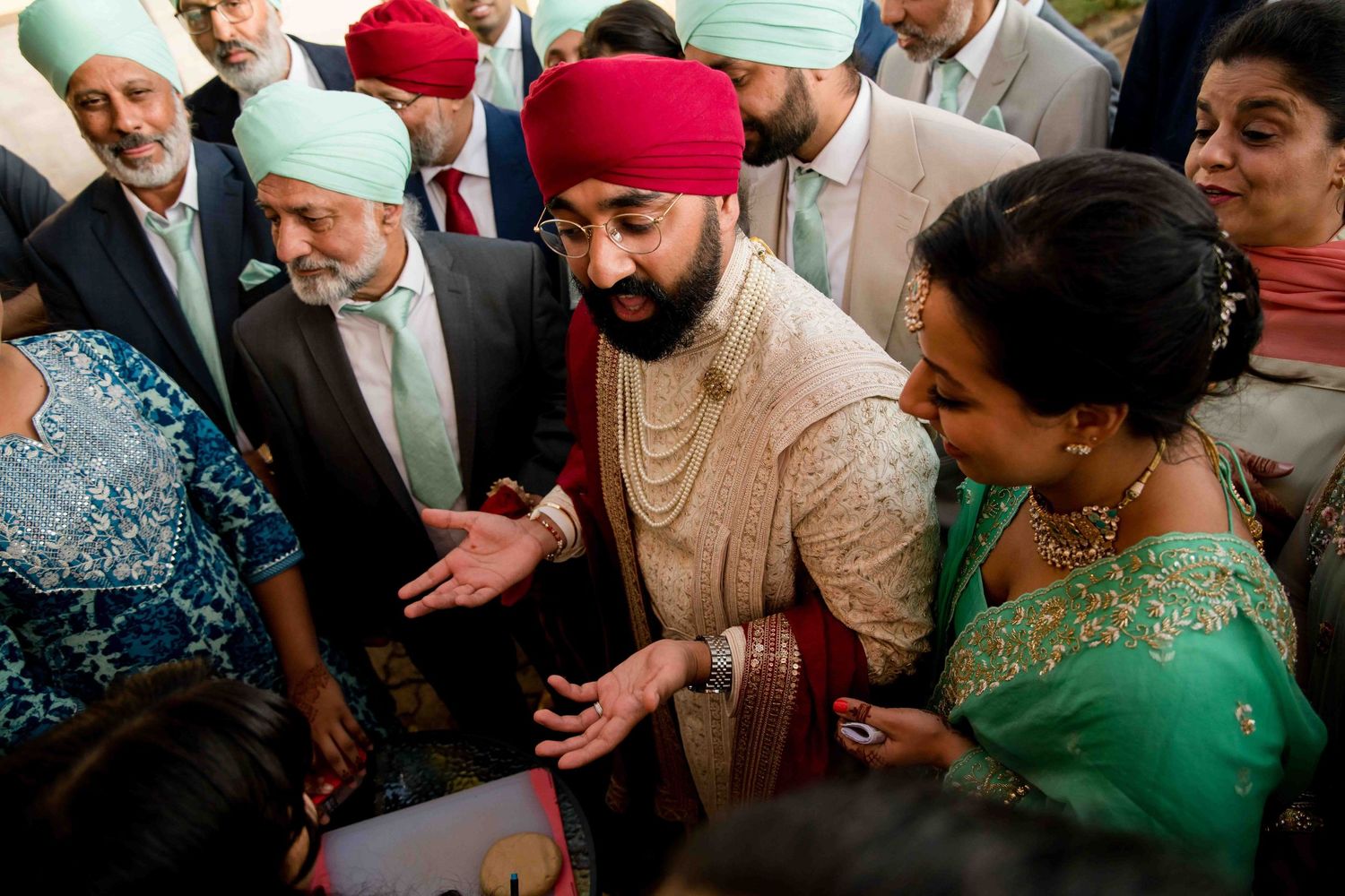 Festive gathering during Sikh wedding celebration with guests in traditional formal attire.