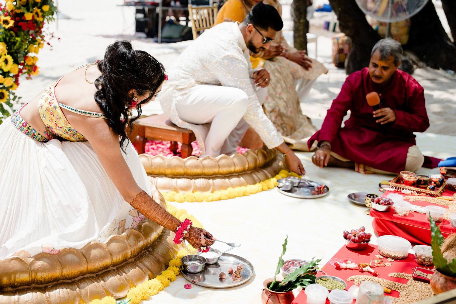 People gather around a table to cut and serve a traditional wedding cake at a reception celebration.