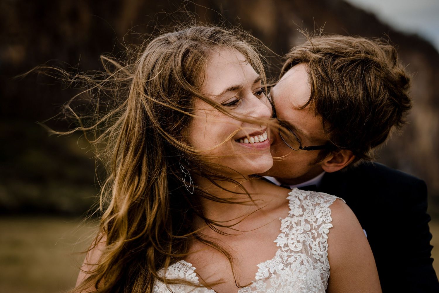 A romantic couple embraces during a golden hour outdoor photoshoot with natural lighting and warm tones.