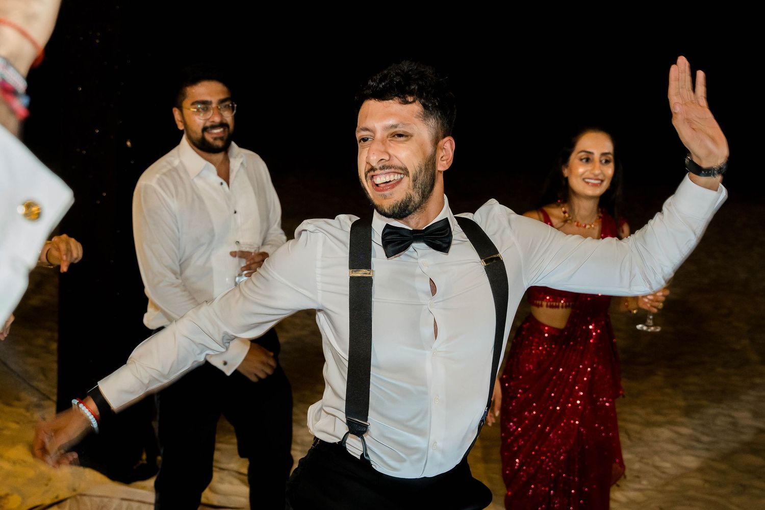 Wedding guests dance and celebrate together on the dance floor at an evening reception.