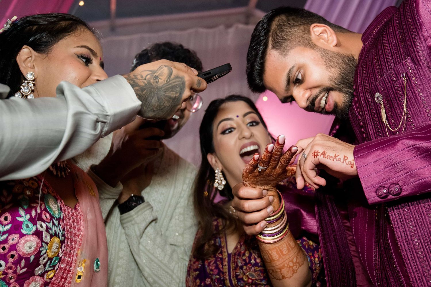 Wedding guests feed sweets to each other during a traditional Indian celebration.