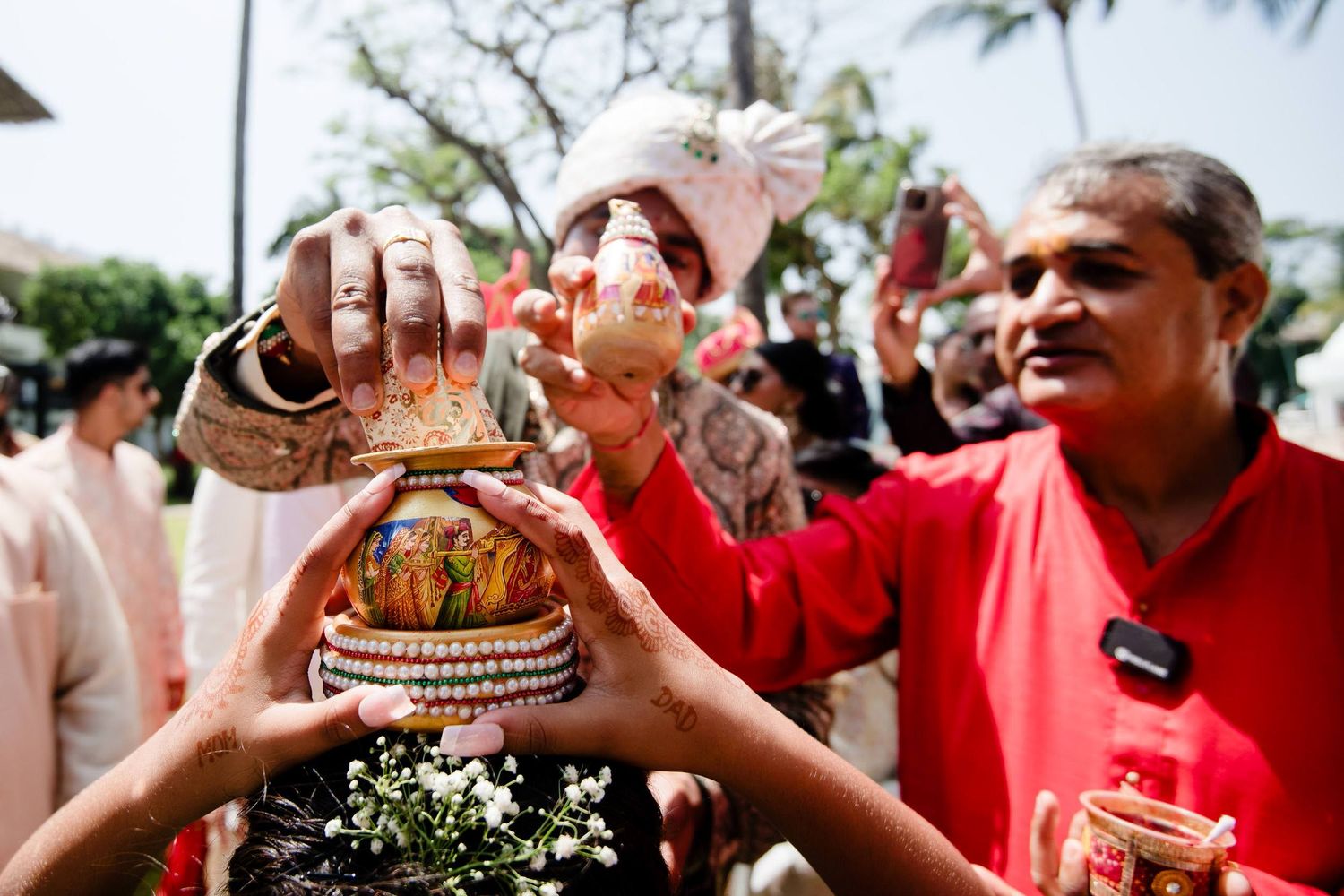People toasting with drinks at an outdoor celebration while wearing red and white clothing.