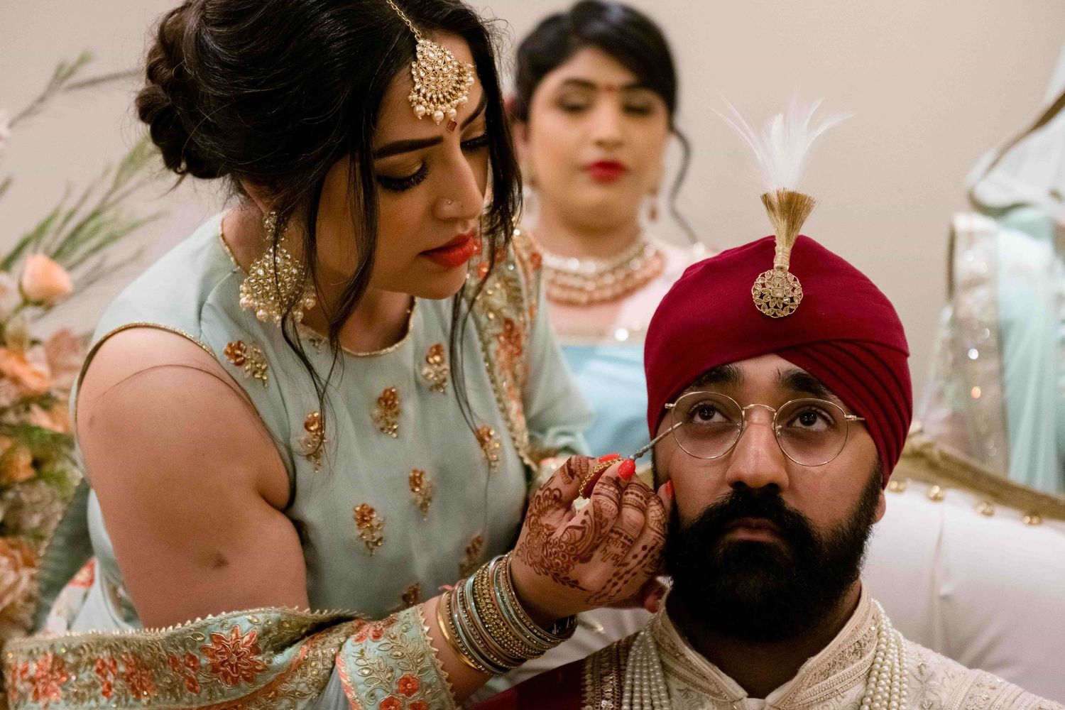An intimate moment during an Indian wedding ceremony with traditional attire and decorations.