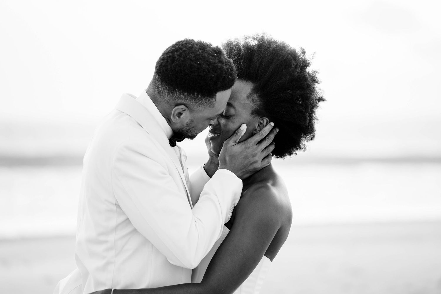 A romantic black and white photo series showing tender moments between a couple at the beach.
