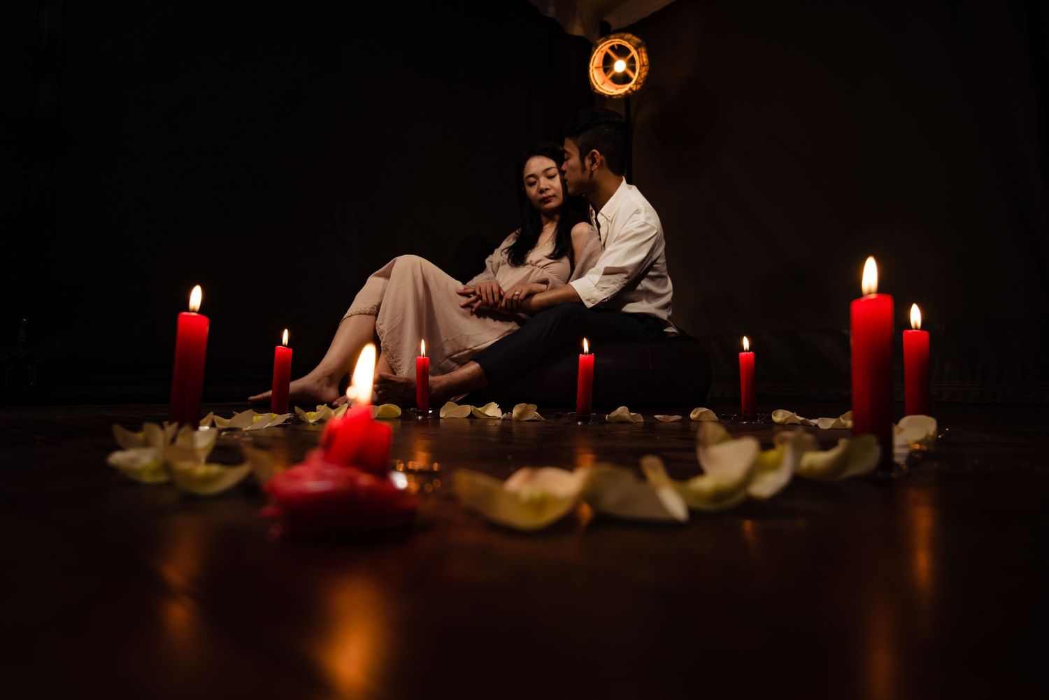 Red candles and decorative elements arranged in a dark atmospheric setting.