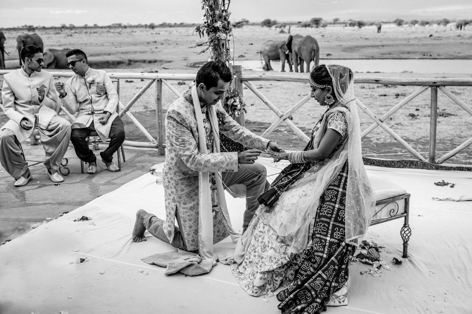 Wedding guests relax in rustic outdoor seating during a countryside celebration.