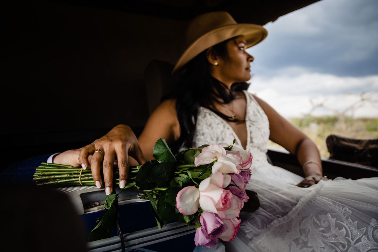 Wedding bouquet with pink orchids held against a sunlit background.