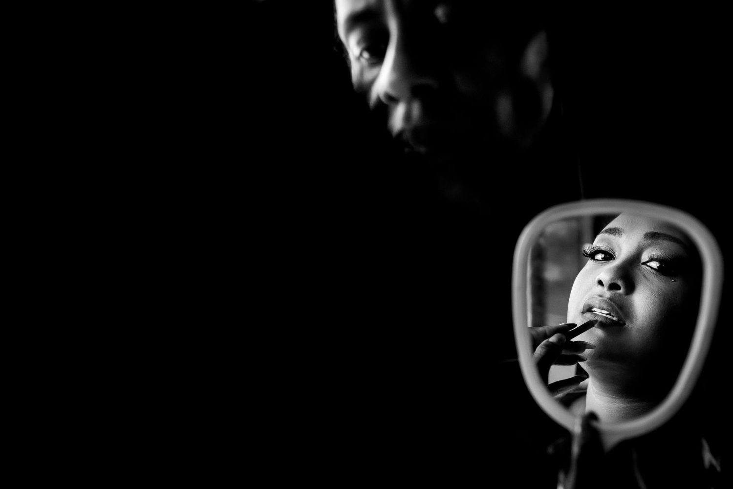 Artistic black and white portrait with dramatic lighting and shadows.