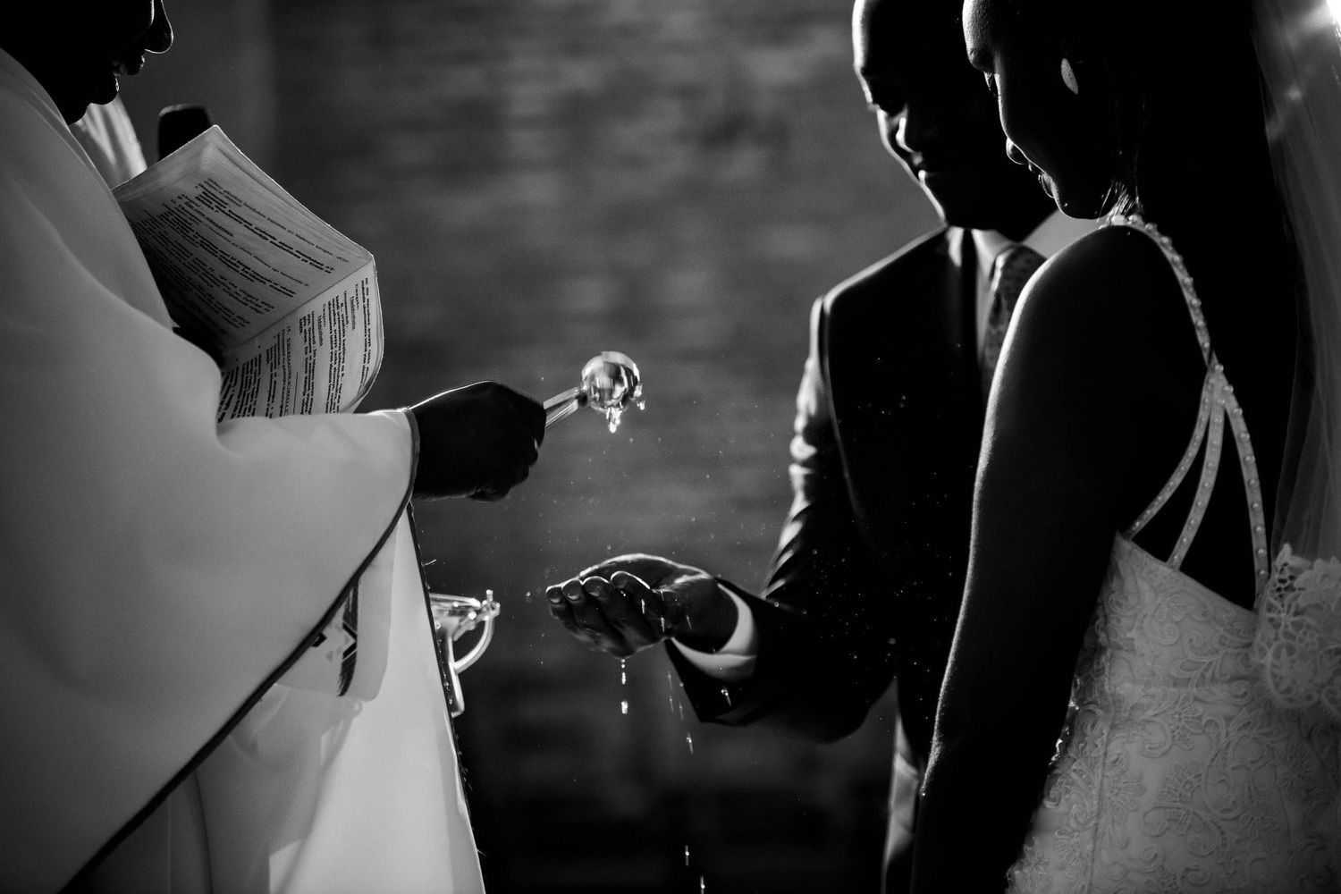 Dramatic silhouettes capture tender moments between a couple during their wedding ceremony.